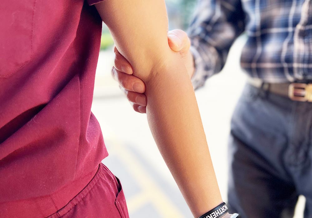 care assistant helping older man to walk in assisted living